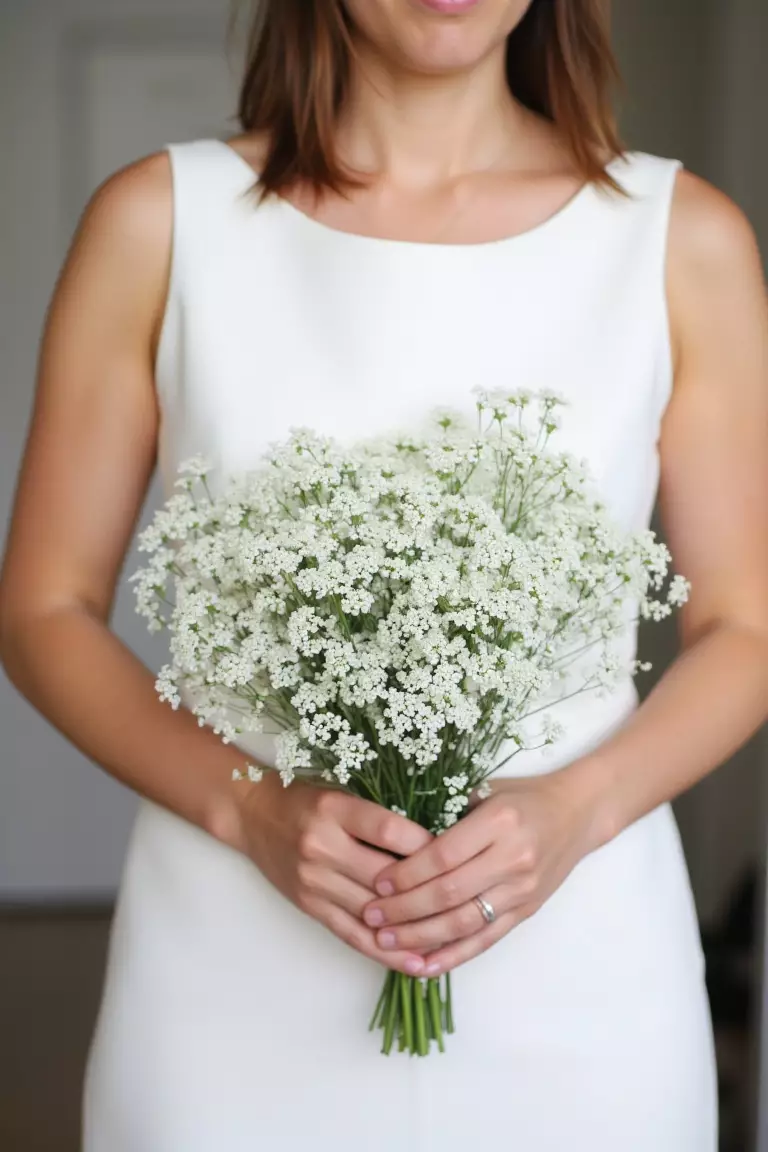 Queen Anne's Lace and Cosmos A photo of a bridesmaid holding a simple, textured bouquet of Queen Anne's lace and cosmos with long stems and petite blooms