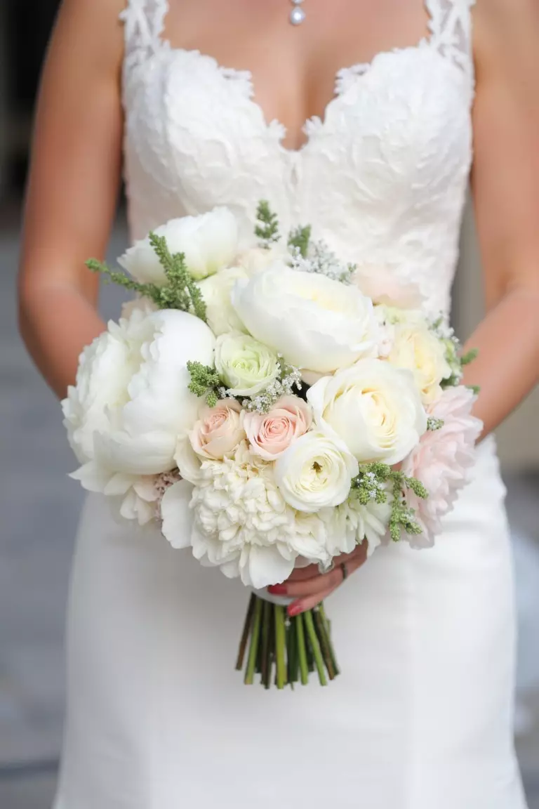 English Garden Roses A photo of a bride holding a soft bouquet of English garden roses, peonies, and ranunculus in white, ivory, and blush hues