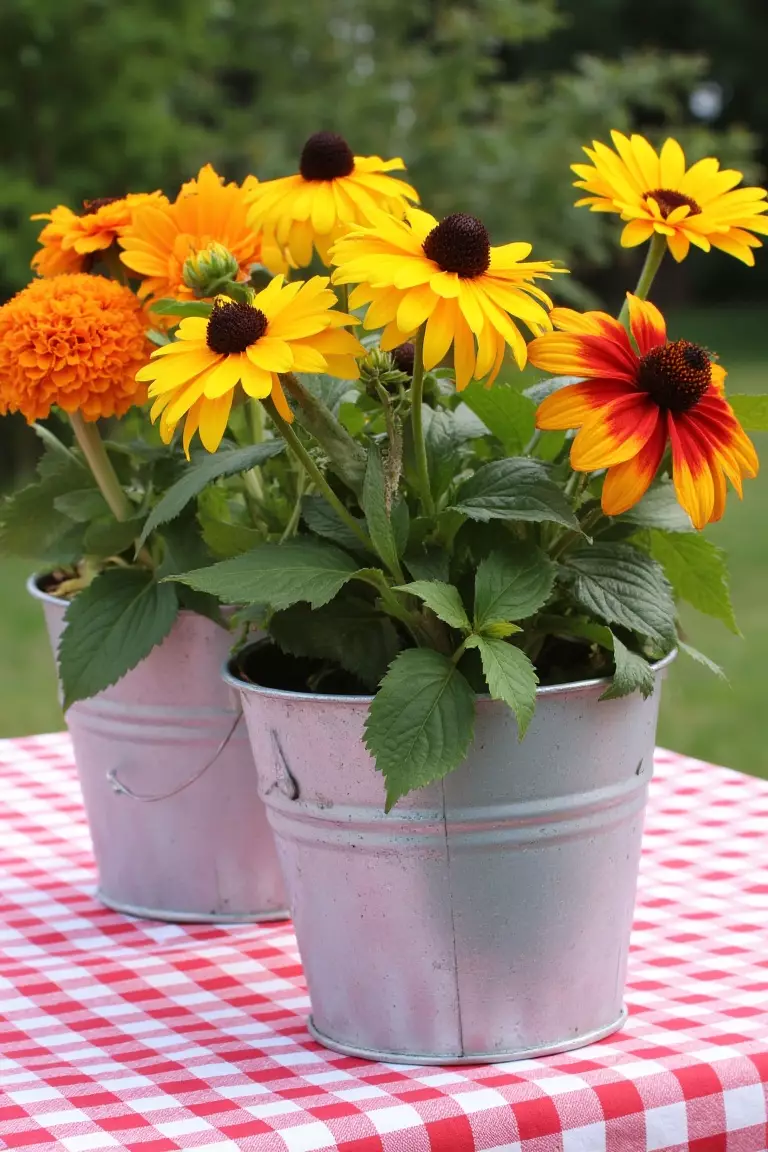 Country Chic Wildflower Centerpiece A photo of tin pails with marigolds, bachelor buttons, and rudbeckia on gingham tablecloths