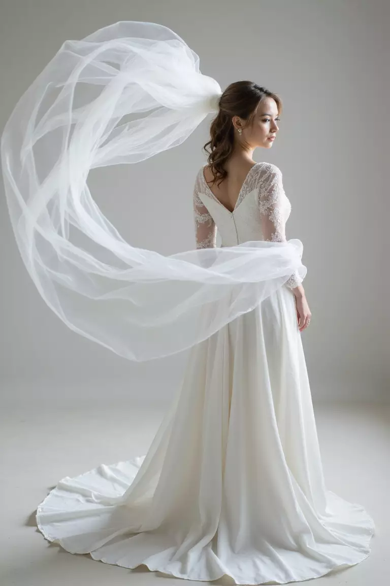 Classic Veil Toss Shot A professional photo, similar to a photo in a wedding magazine, of a bride's veil dramatically tossing in the air, creating elegant flowing fabric shapes.