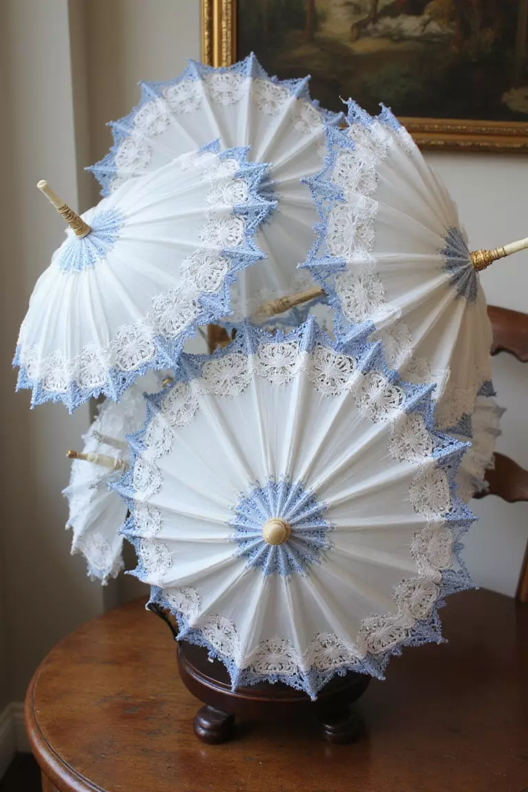 White Parasols With Blue Trim A professional photo, similar to a photo in a wedding magazine, of delicate white lace parasols with blue trim displayed in a vintage stand for wedding guests.