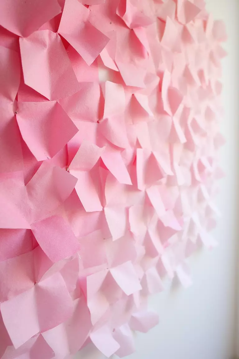 Ombre Tissue Paper Wall A professional photo, similar to a photo in a wedding magazine, of squares of tissue paper in shades of pink, fading from dark to light, attached to a wall creating an ombre effect.