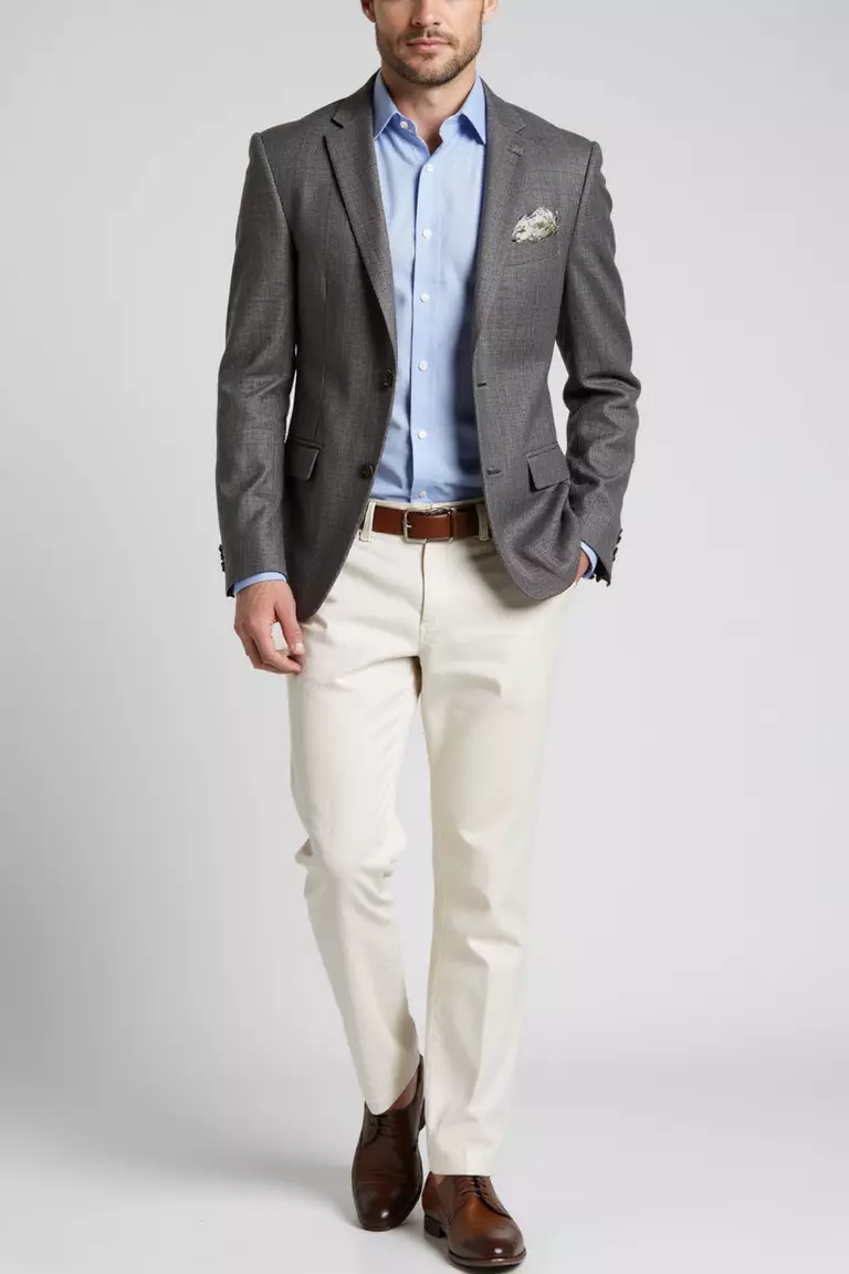Stone Grey Blazer, Ivory Pants, Soft Blue Shirt, Brown Dress Shoes A professional photo, similar to a photo in a wedding magazine, of a man wearing a textured stone grey blazer, ivory linen pants, soft blue button-up shirt, and polished brown dress shoes.