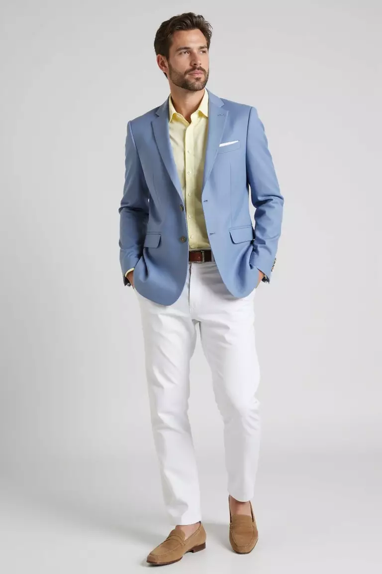 Light Blue Blazer, White Trousers, Pastel Shirt, Neutral Loafers A professional photo, similar to a photo in a wedding magazine, of a man wearing a light blue blazer, crisp white trousers, pastel yellow shirt, and beige suede loafers.