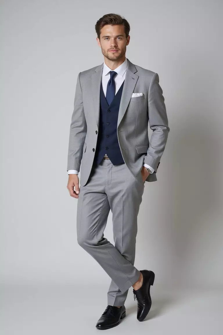 Light Grey Suit, White Dress Shirt, Navy Tie, Black Oxfords A professional photo, similar to a photo in a wedding magazine, of a man wearing a light grey suit with a crisp white dress shirt, navy blue tie, and polished black oxford shoes.