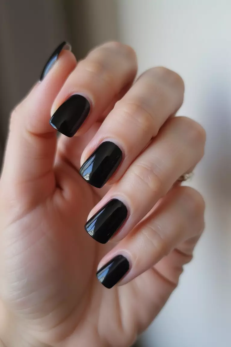 Classic Black French Tips Close-up of a woman's hand with five fingers featuring black French tips against natural base, showing clean lines and glossy finish, perfect for wedding elegance.