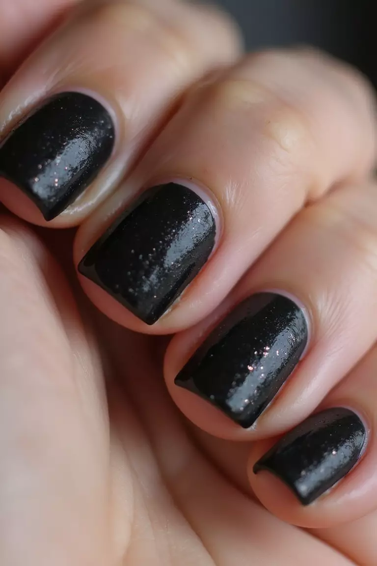 Black Sugar Coating Effect Close-up of a woman's hand with five fingers featuring black nails with textured sugar-like granules creating sparkling dimension across surface.