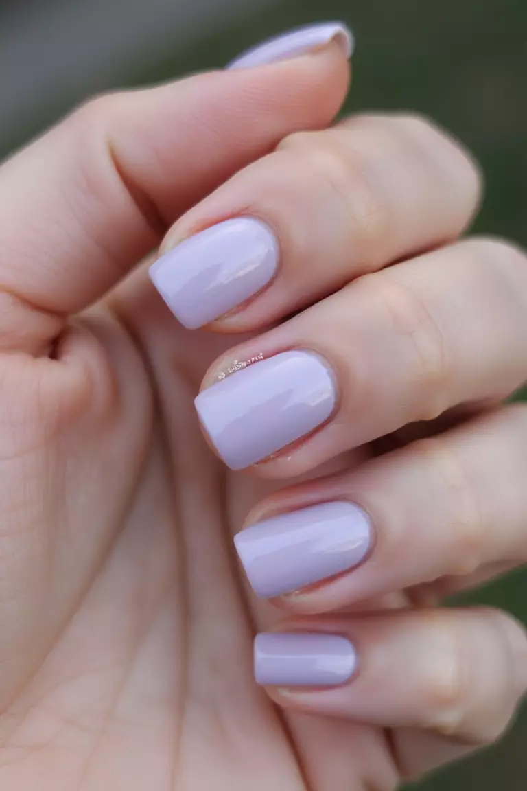 Sheer Lilac Close-up of a woman's hand with five fingers featuring short nails with sheer, pale lilac polish creating a delicate, romantic look.