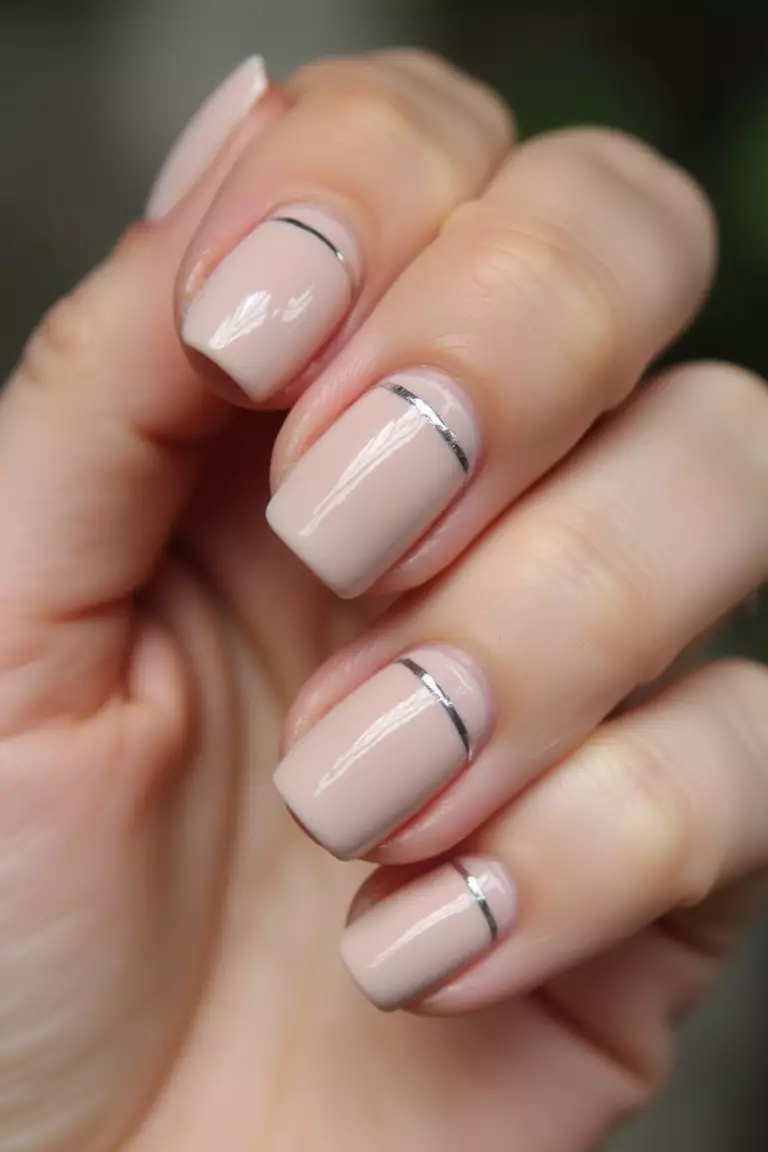 Thin Silver Stripe Close-up of a woman's hand with neutral nails featuring a thin silver stripe.