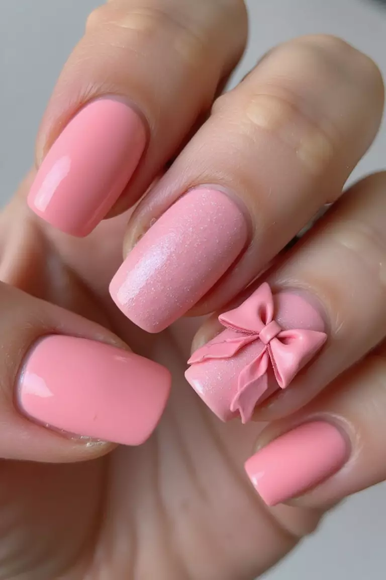 3D Pink Bow Accent Close-up of a woman's hand with five fingers featuring pink nails with a 3D bow sculpture on ring finger, textured and dimensional.