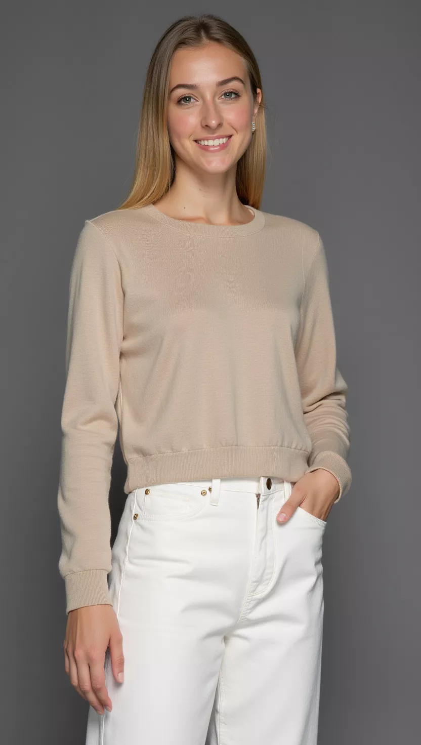 Creamy Comfort Crew A beautiful woman in a simple beige long-sleeved crew-neck sweater and white pants, female fashion model full body shot, editorial style photography.