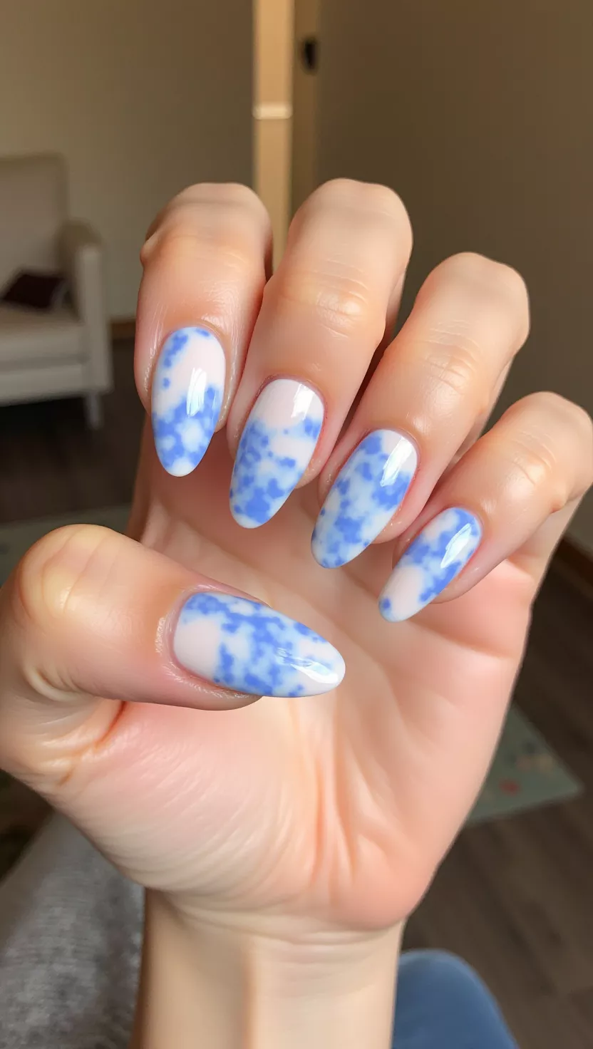 Jelly Marble close-up shot of a woman’s hand with five fingers showing nails with a semi-transparent, jelly-style light blue and white marbled effect with a high-shine finish, room background