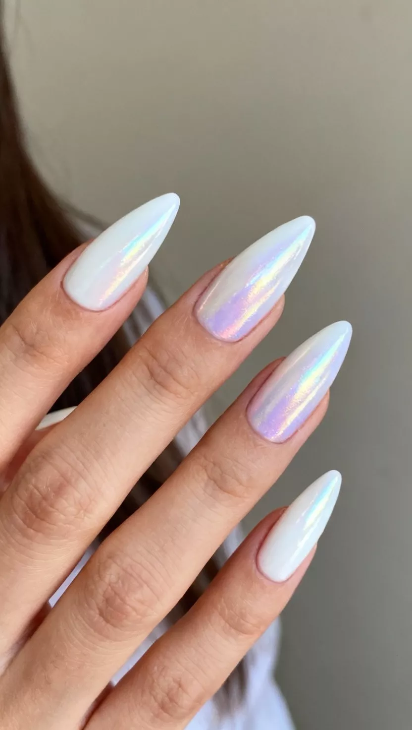 close-up shot of a woman’s hand showing nails with a glossy iridescent white polish, elongated into a pointed almond shape, close-up nail photography, nail polish designs, pinterest aesthetic