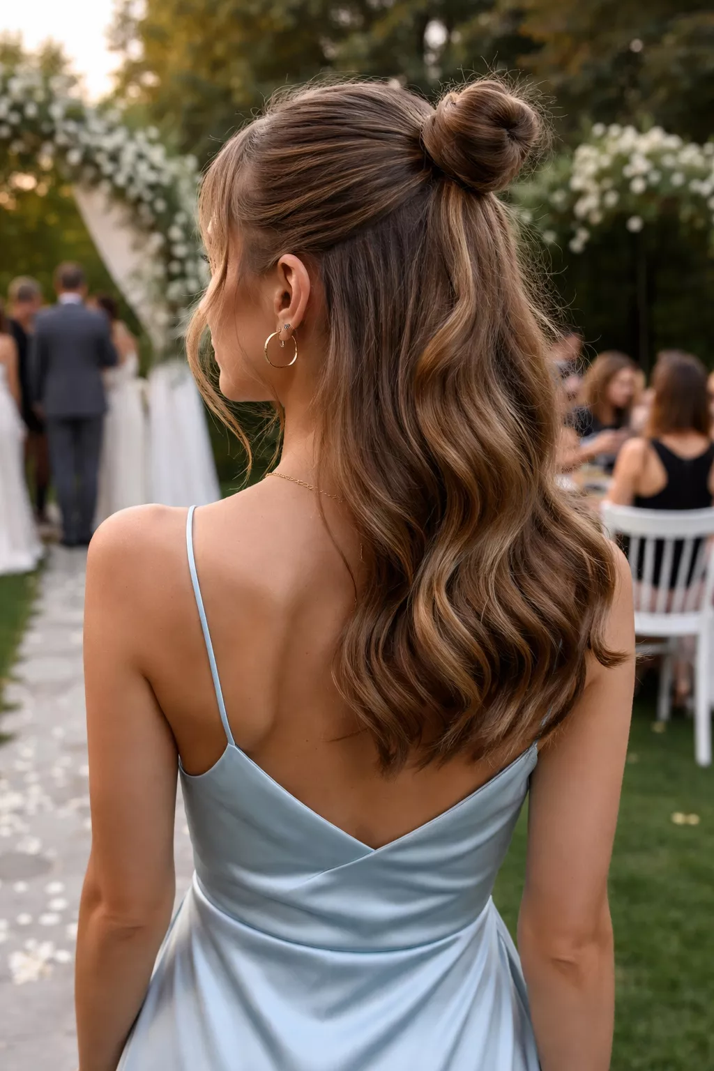 close-up casual photo of a 25-year-old wedding guest wearing a light blue satin dress with a polished half-up mini bun, back view, shot with an iPhone 15 Pro Max