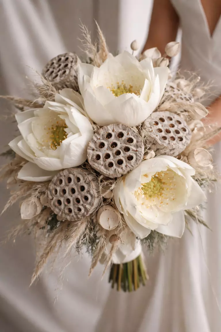 A realistic photo of a wedding bouquet featuring large lotus flowers and textured lotus pods, minimal greenery, architecturally striking design, neutral background, sharp focus on the unique textures.