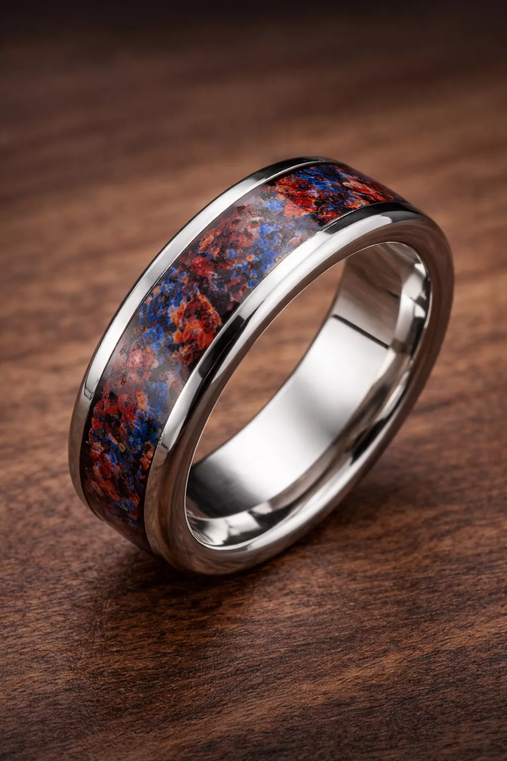 A realistic photo of a polished silver wedding ring with a colorful red and blue fossilized dinosaur bone inlay.