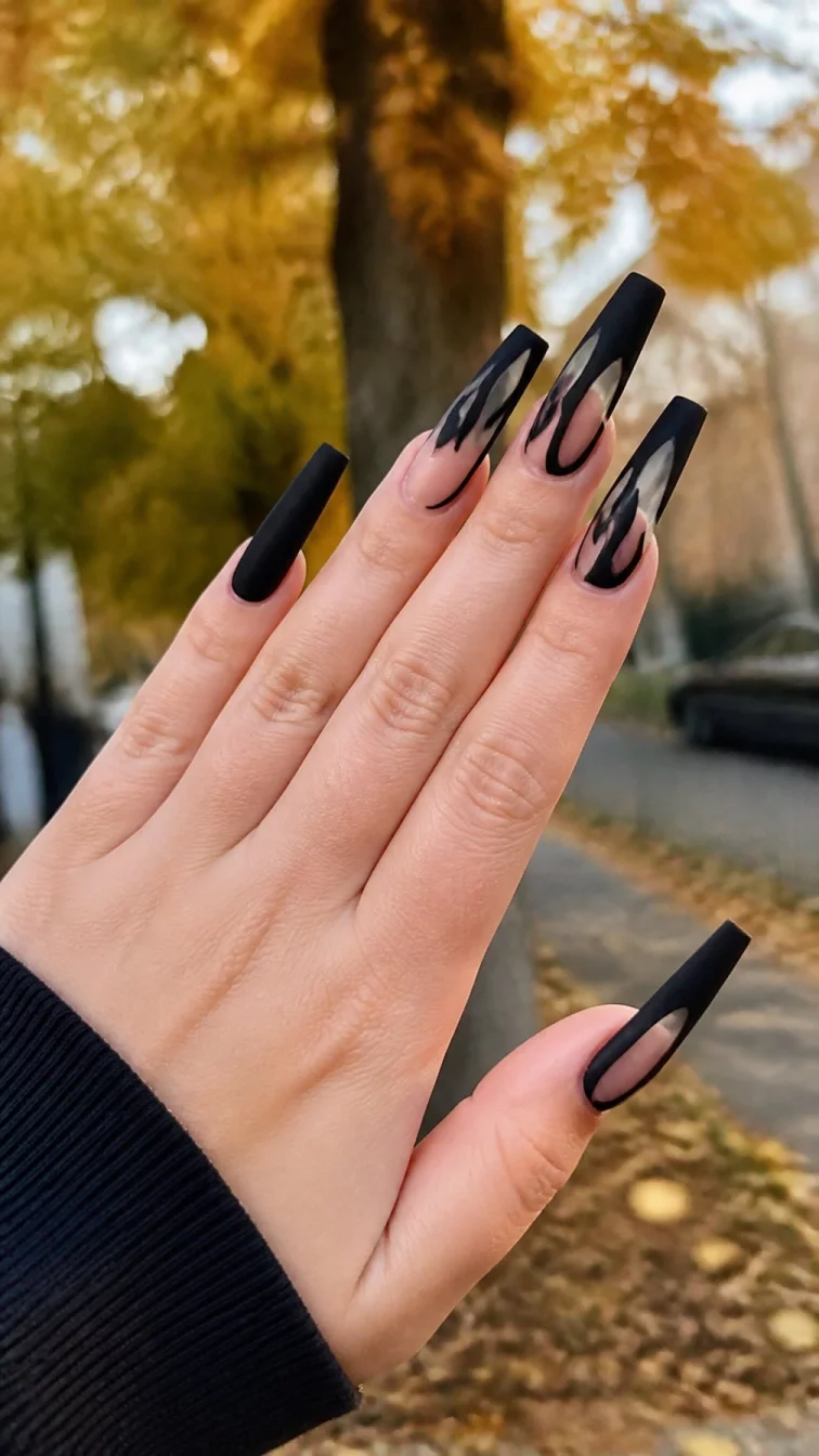 A photorealistic close-up shot of a woman's light skin tone hand with five fingers, showcasing very long coffin-shaped nails featuring a matte black finish interwoven with clear sections, outdoor fall background