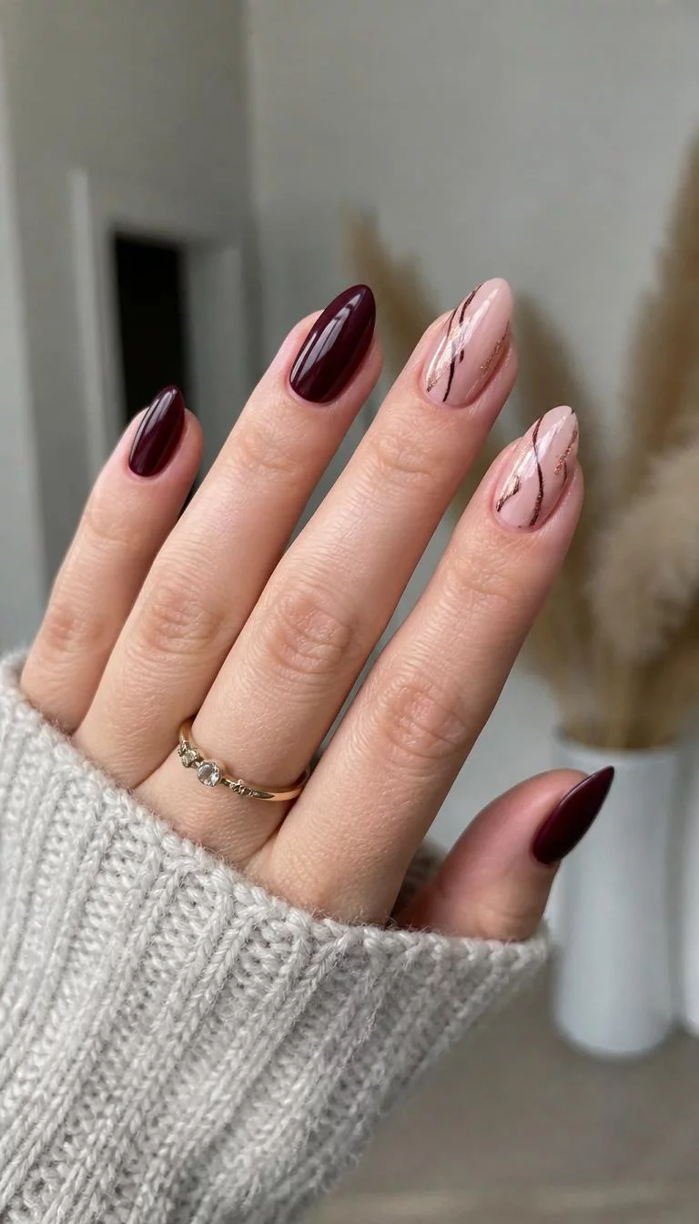 Plum Polish And Rose Gold Accents A photorealistic close-up shot of a woman's light skin tone hand with five fingers, showcasing almond medium length nails with some deep plum nails and others featuring a neutral base with dark lines and rose gold accents, indoor background
