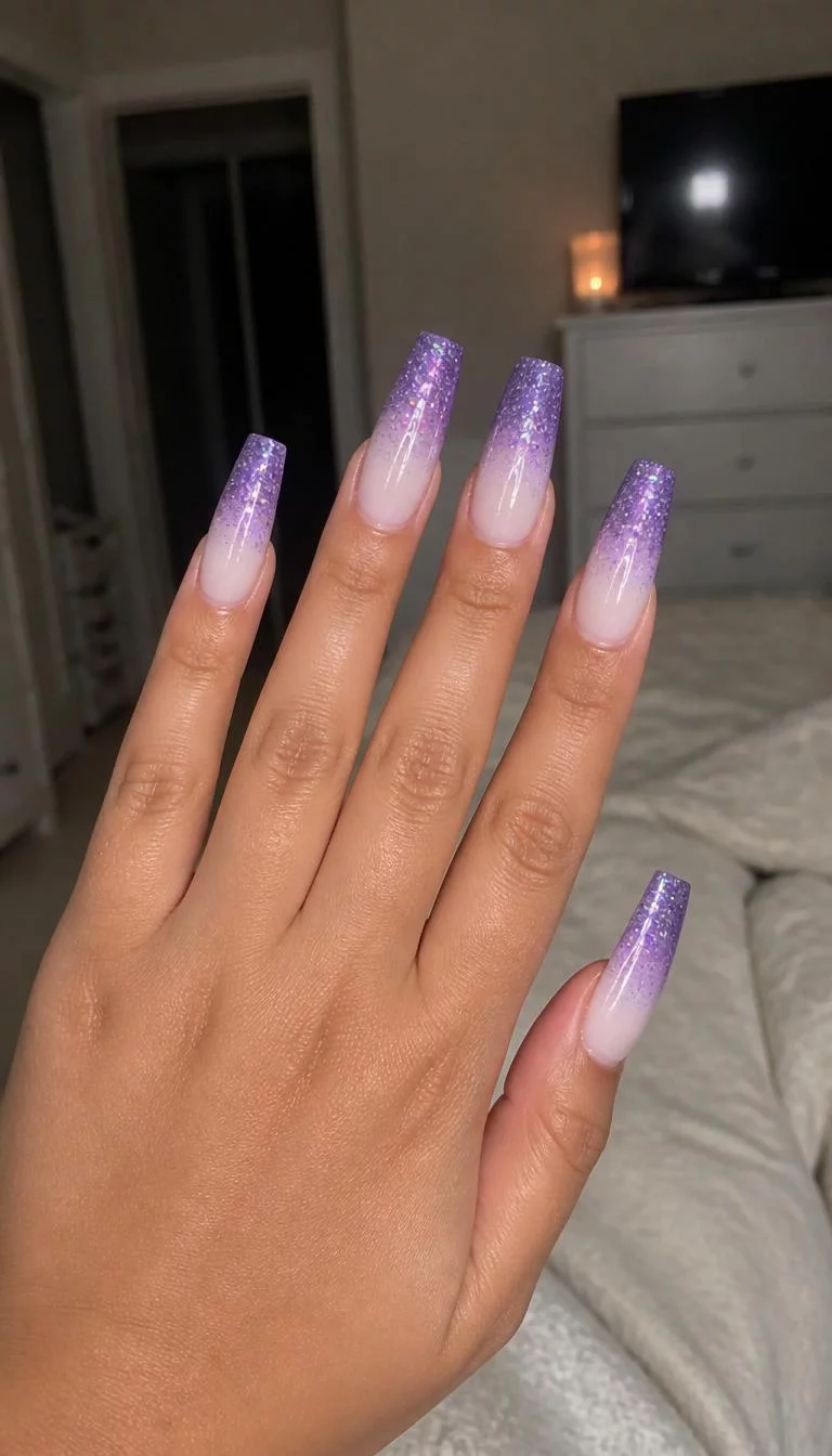 Purple Glitter Ombre Coffin Nails A photorealistic close-up shot of a woman's medium skin tone hand with five fingers, showcasing coffin long nails featuring an ombre effect from a light opaque color to deep purple glitter, bedroom background